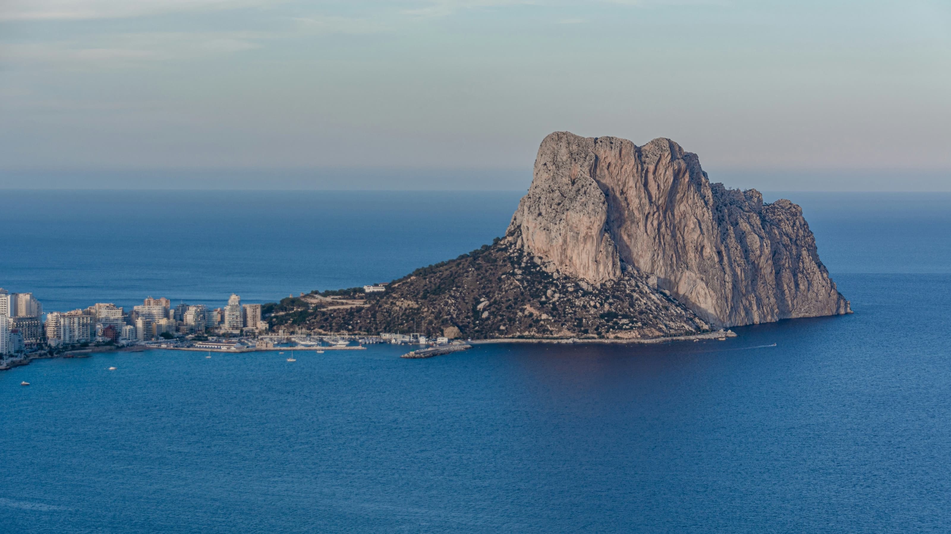 Le rocher d’Ifach surgissant de la mer au crépuscule, avec le port et la ville de Calp à sa gauche