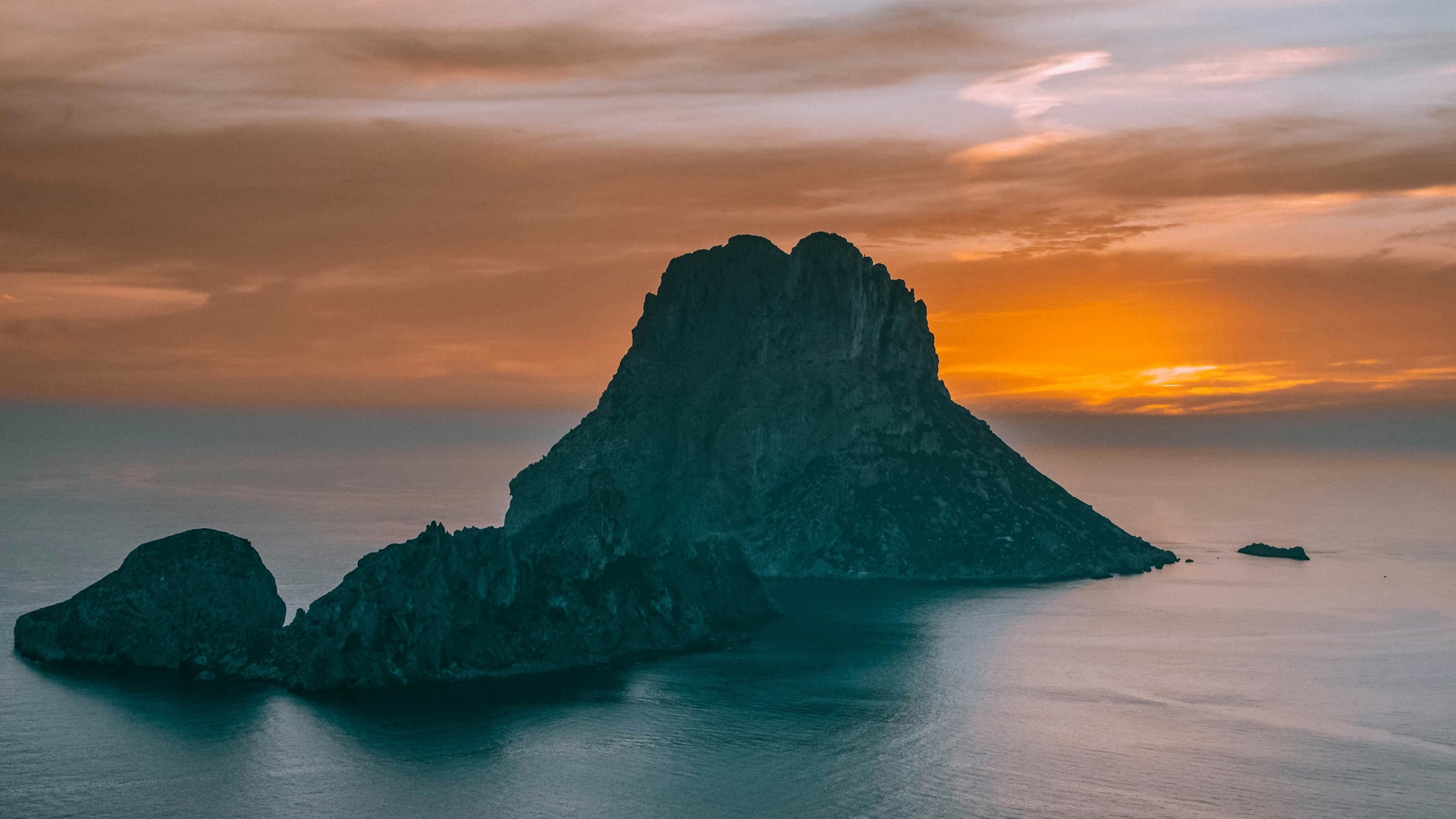 La silhouette d’es Vedrà se découpant sur un coucher de soleil orange