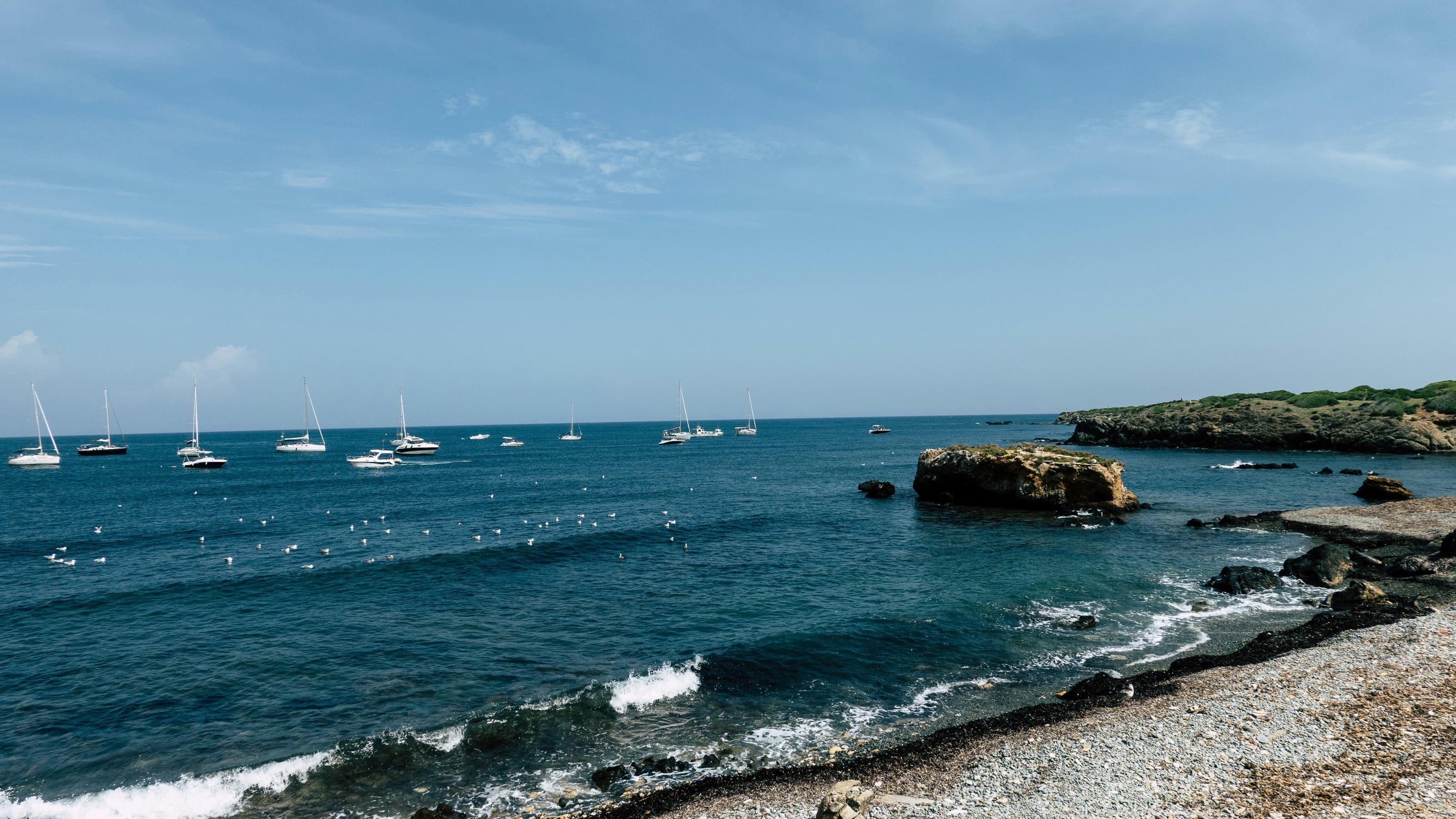 Voiliers au mouillage devant la côte rocheuse de l’île de Tabarca, dans une eau claire